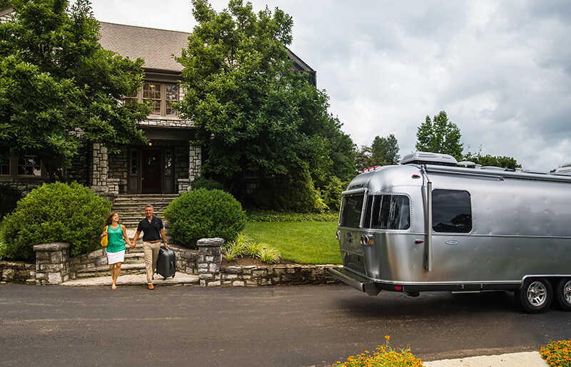 Airstream RV Classic Travel Trailer in front of house