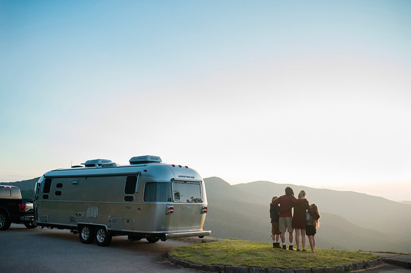 Family with Airstream RV Flying Cloud Travel Trailer by mountains