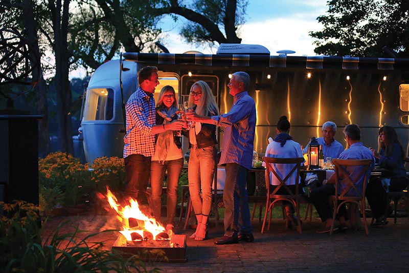 Family camping at night with Airstream Globetrotter Travel Trailer