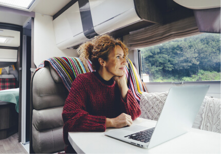 Woman working on her computer in an RV