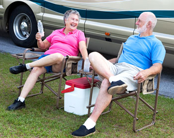 Older couple relaxing by their RV.