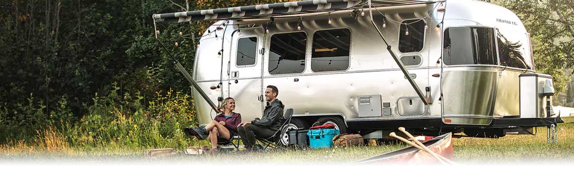 Couple sitting by their Airstream RV
