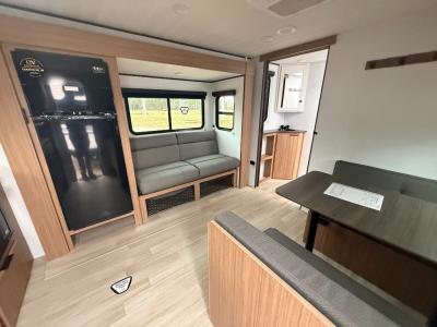 Living area slide contains jack knife sofa and refrigerator in new 2026 Keystone RV Passport Classic 210RKC