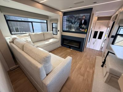 L-shaped sofa, smart TV over fireplace, in spacious living area in new 2026 Palomino River ranch 394RKL