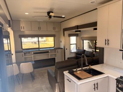 Opposing slides in spacious living area  with a sectional sleeper sofa in the new 2026 Prime Time RV Sanibel 34LOUNGE