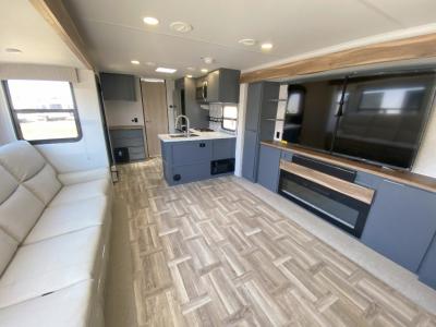 Dual opposing slides make a spacious living area - long sofa and 70" TV with fireplace complete the look