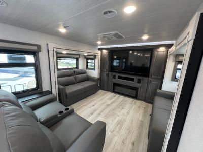 2025 East to West 380FL fifth wheel spacious living area with sofas, theater seating, entertainment center and fireplace