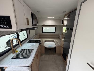 Kitchen area with appliances and U-shaped dinette convertible bed in new Thor Chateau 19Z Class C motorhome
