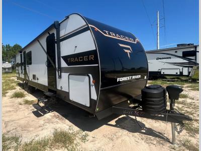 Front/side view of new 2026 Prime Time Tracer 295DB travel trailer with power awning over both doors