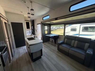 Living room  and kitchen with center island in new 2026 Forest River cardinal 35FUN fifth wheel