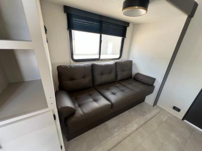 Jack knife sofa in living area slide converts into a bed in the new 2026 prime Time Tracer 235RK RV