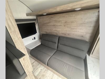 Sofa with queen-size Murphy bed at front of new 2026 Gulf Stream Ameri-Lite Super Lite 192DS travel trailer