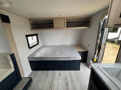 Queen bed with overhead storage and bedside cabinet in new 2025 prime Time LT 17FQS RV
