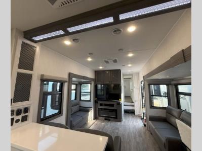 Spacious living area with two tri-fold sofas, theater seats, and TV with fireplace