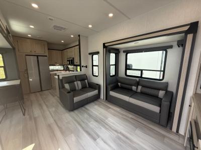 Spacious living area with tri-fold sofa and theater seats in new 2026 Forest River Cardinal 33CHEF fifth wheel