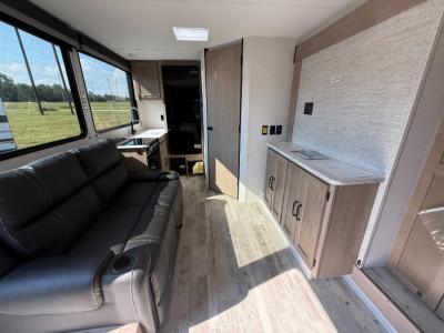 Sofa and entertainment center in living area of new 2026 Gulf Stream Conquest Ultra Lite 228SB RV