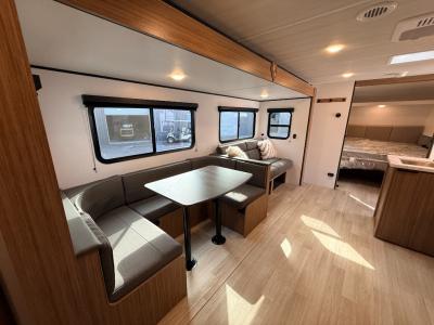 Large slide in living area contains u-shaped booth dinette and jack knife sofa of new 2026 Keystone Passport Classic 284QB