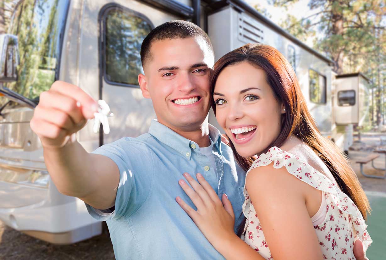 Young Military Couple Holding In Front of New RV.