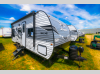 Front angle view of the 2025 Jayco Jay Flight SLX 210QB travel trailer parked on grass under a bright blue sky.