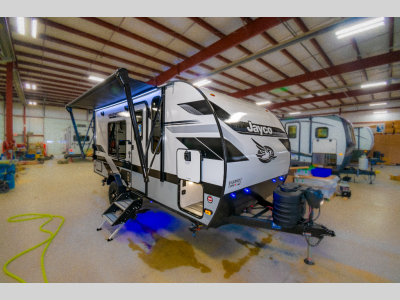 Front exterior of 2025 Jay Feather Micro 173MRB with propane tanks, tongue jack, and indoor showroom lighting.