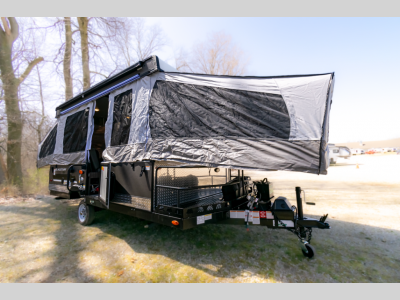 Front angle view of the 2024 Forest River Flagstaff SE 228BHSE pop-up camper, showcasing its compact design and open tent setup.
