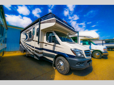 Passenger-side exterior of the 2016 Coachmen Prism 2200 LE motorhome under a blue sky.