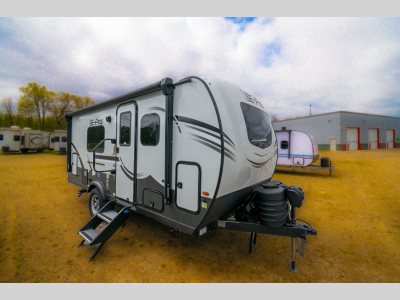 Side profile with entry steps, awning, and slide-out extended.