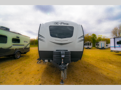 Front view with aerodynamic nose cap, power tongue jack, and dual propane tanks.