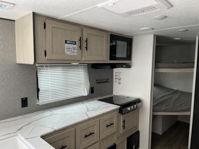 Kitchen area with overhead cabinets, microwave, and countertop space