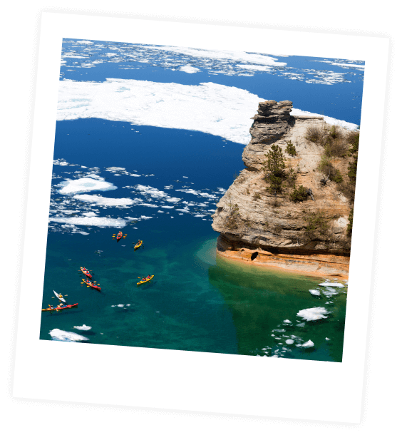 People kayaking near cliff