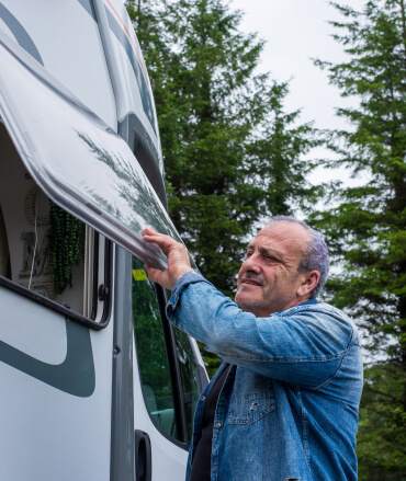 Man opening a window on his RV