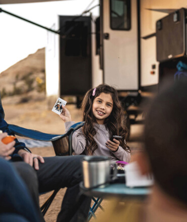 Girl playing cards with her family