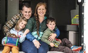 family of four smiling in their RV