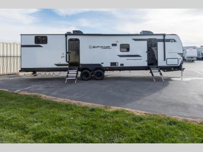 Curbside view showing main entry, large awning, and dual axles
