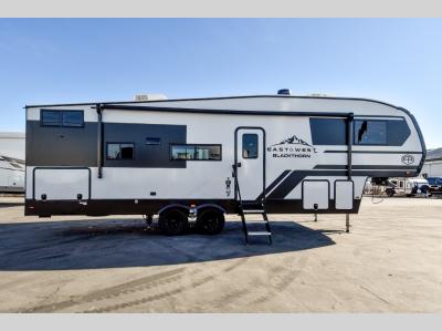 Curbside exterior of the 2025 Blackthorn 27BH-OK highlighting large slide-out and double axle design.