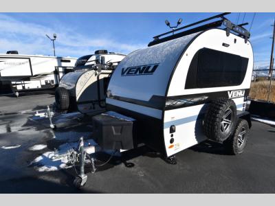 Side view with spare tire, off-road wheels, and hitch box