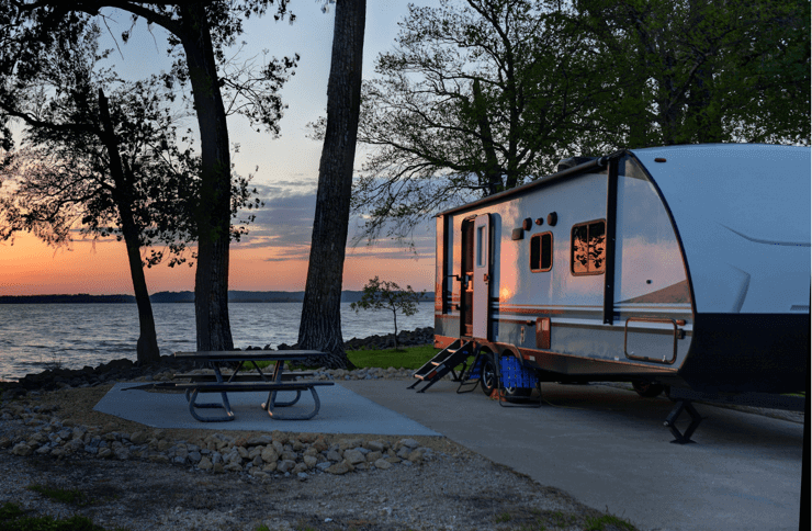 travel trailer at sunset by a lake