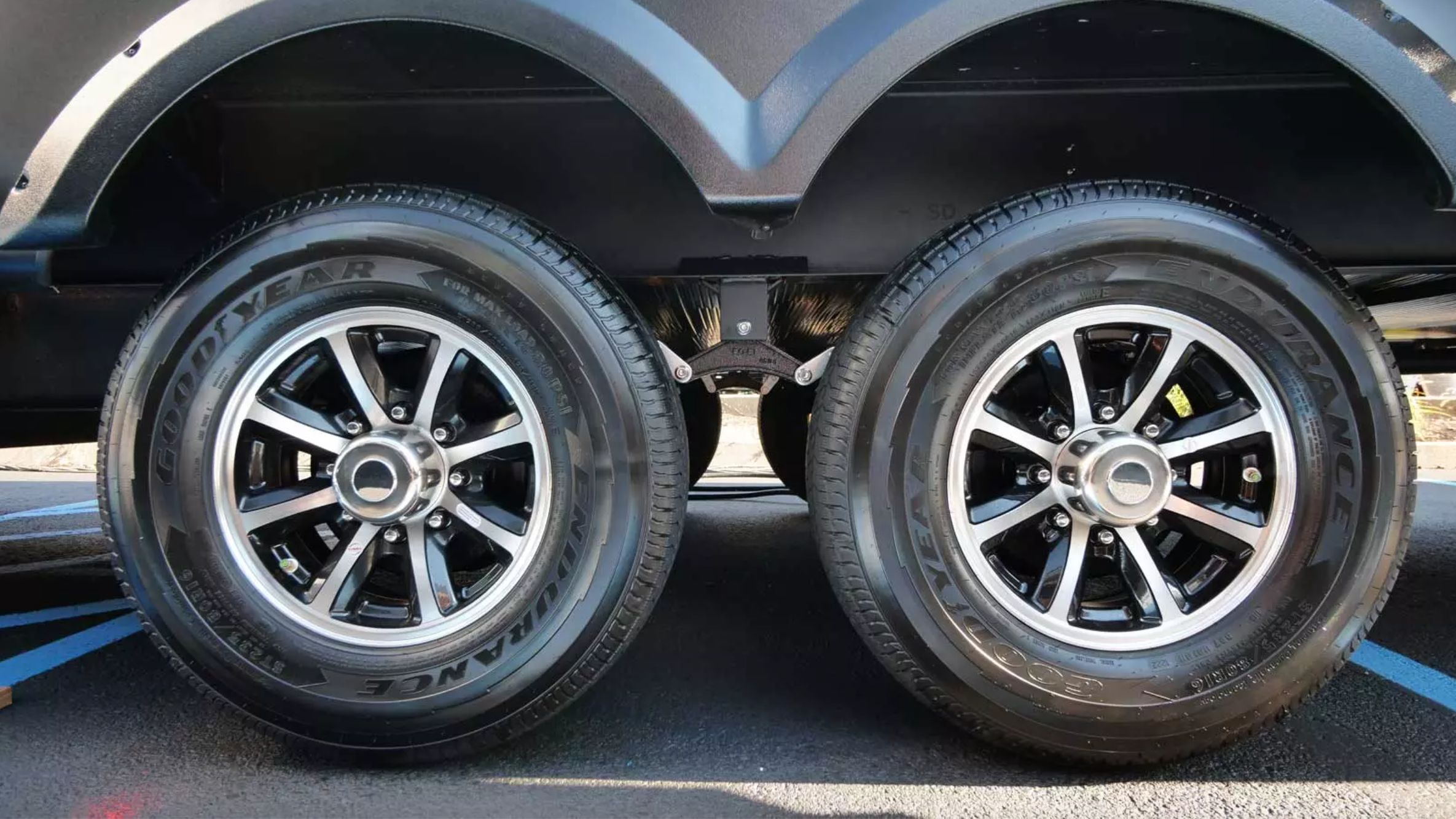 A close-up of two Goodyear RV tires in a parking space