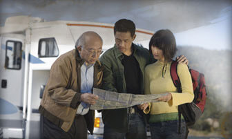 A family looking at a map outside of their RV.