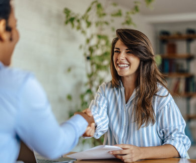 Happy woman shaking hands with a financial assistant