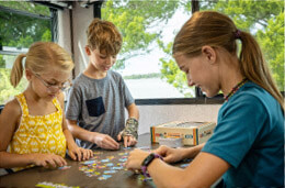 Children putting together a puzzle inside their RV.