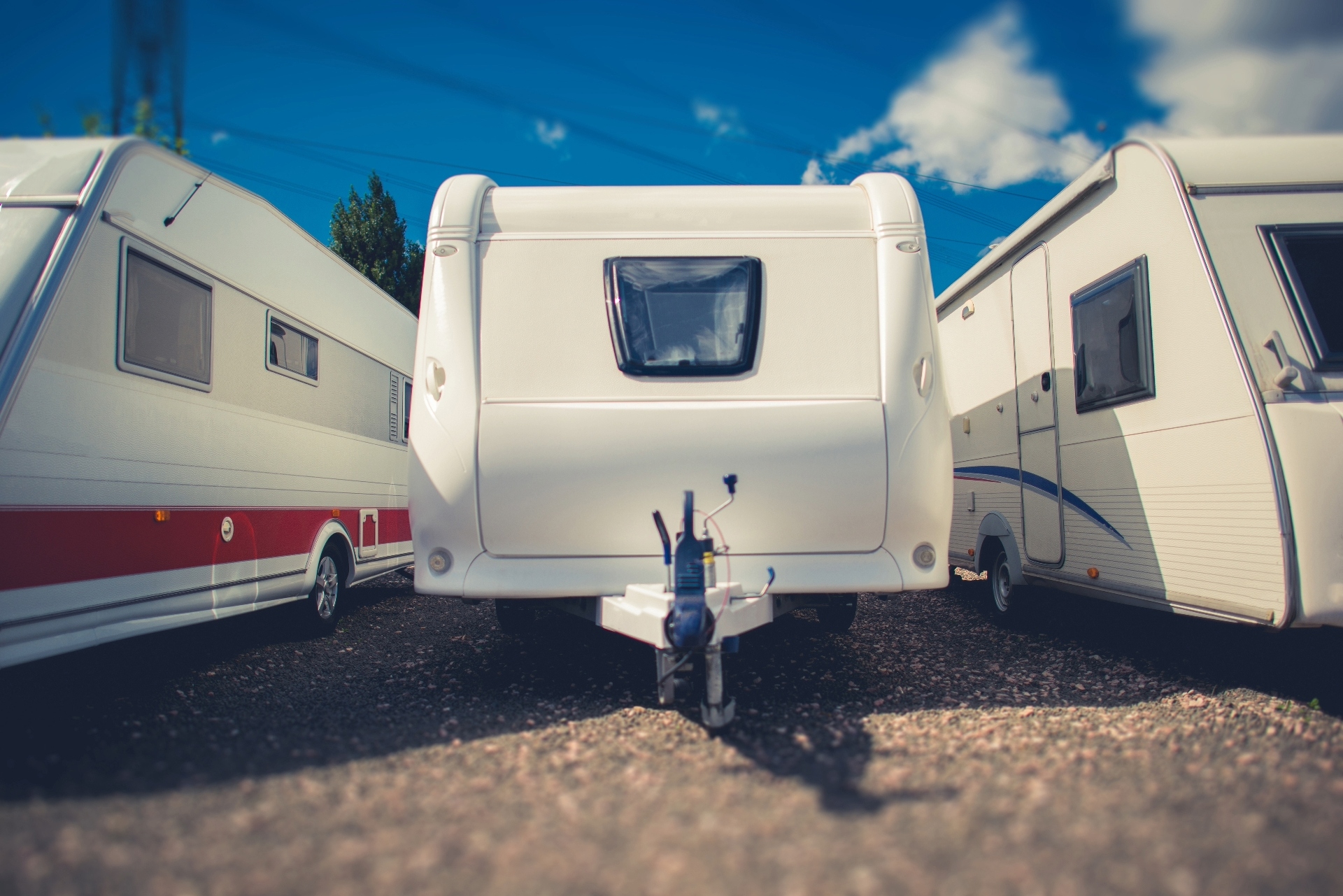 A row of RV travel trailers at an RV dealership.