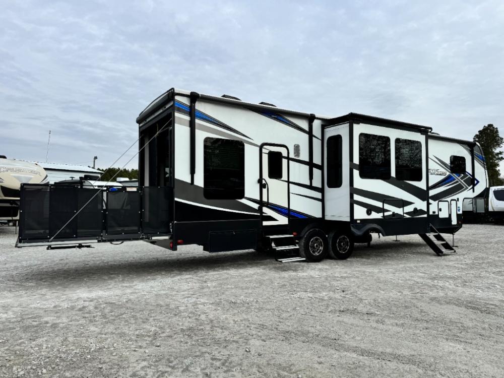 Side profile of Used 2021 Keystone Fuzion 373 Toy Hauler with awnings out at Recreation USA