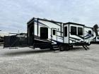 Side profile of Used 2021 Keystone Fuzion 373 Toy Hauler with awnings out at Recreation USA