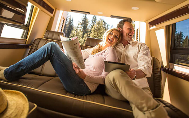 Couple Sitting Inside Midwest Automotive Designs Daycruiser Motor Home